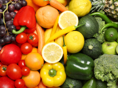 A photo of fruits and vegetables arranged in rainbow color order