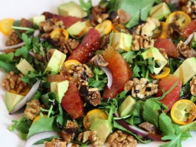 citrus fig and walnut salad on white plate