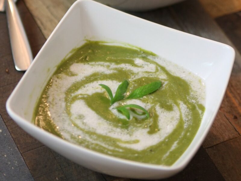 lettuce soup in white bowl with garnish