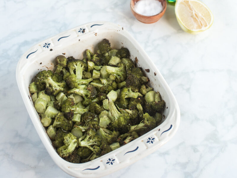 roasted broccoli in pan with lemon and olive oil