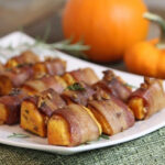 Bite-sized bacon-wrapped spiced pumpkin appetizers on white oblong plate