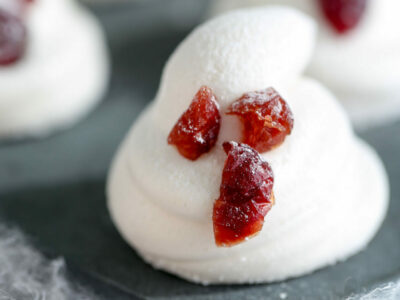 Horizontal image of a homemade marshmallow piped with eyes and mouth made with dried cranberries.