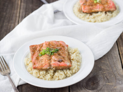 Teriyaki-Inspired Poached Salmon served over cauliflower rice in a white bowl.