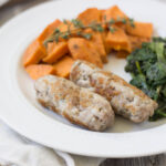 Homemade pork sausage with dried herbs and spices cook and plated wtih sauteed greens and sweet potatoes