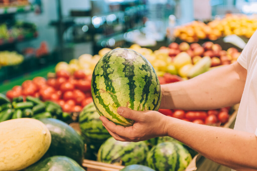 An image of a person shopping for watermelon.