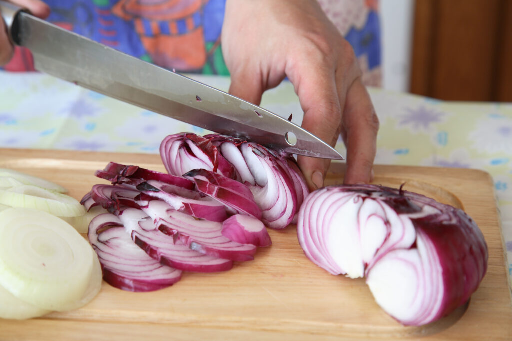 An image of a person slicing onions.