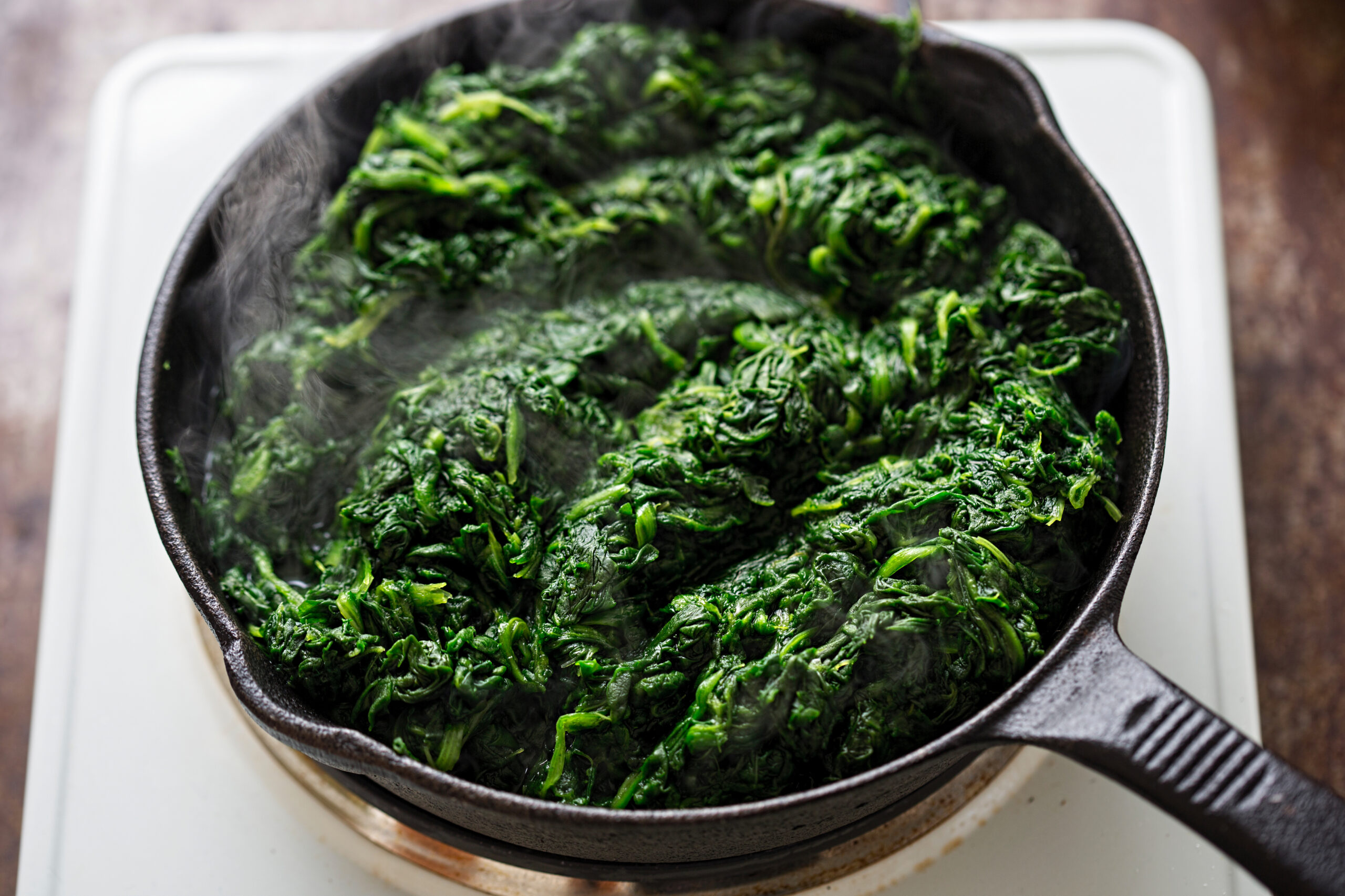 An image of spinach thawing in a frying pan.