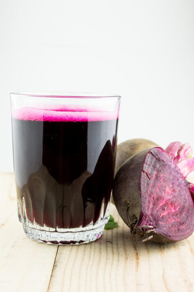 An image of a glass of beet juice with beet.