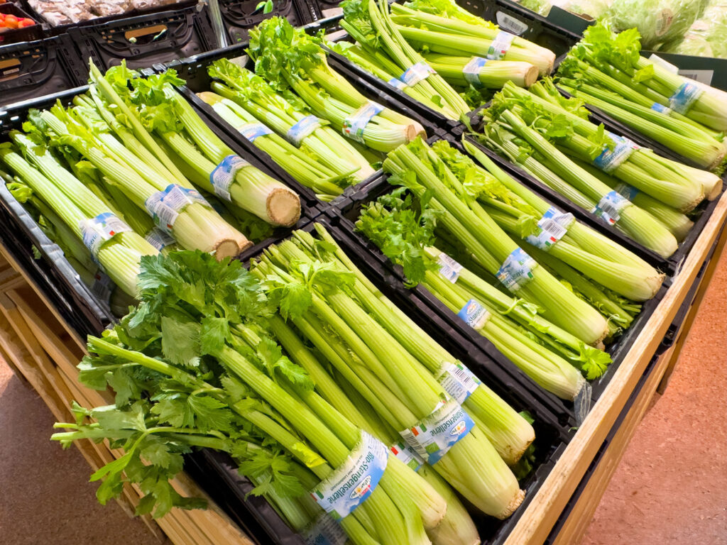 An image of fresh celery stalks on display in the grocery store produce section.