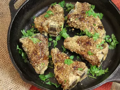 Dukka-crusted lamb garnished with parsley in cast iron pan.