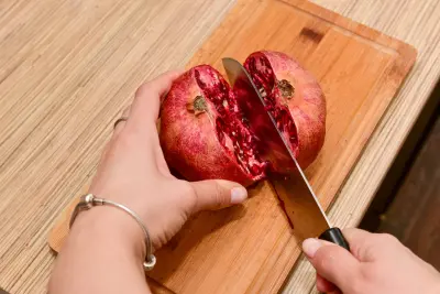 An image of a pomegranate being cut in order to de-seed it.