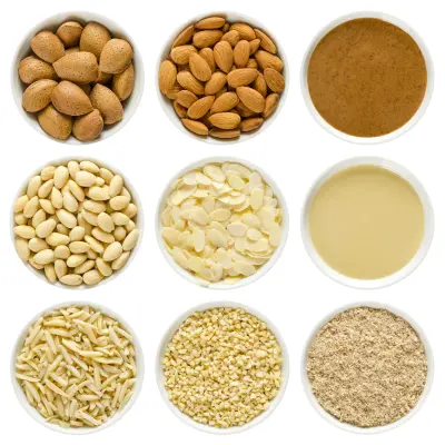 An image of almonds in different forms, including whole nuts with shells, shelled, blanched, chopped, slivered, sliced, ground, brown and white almond butter.